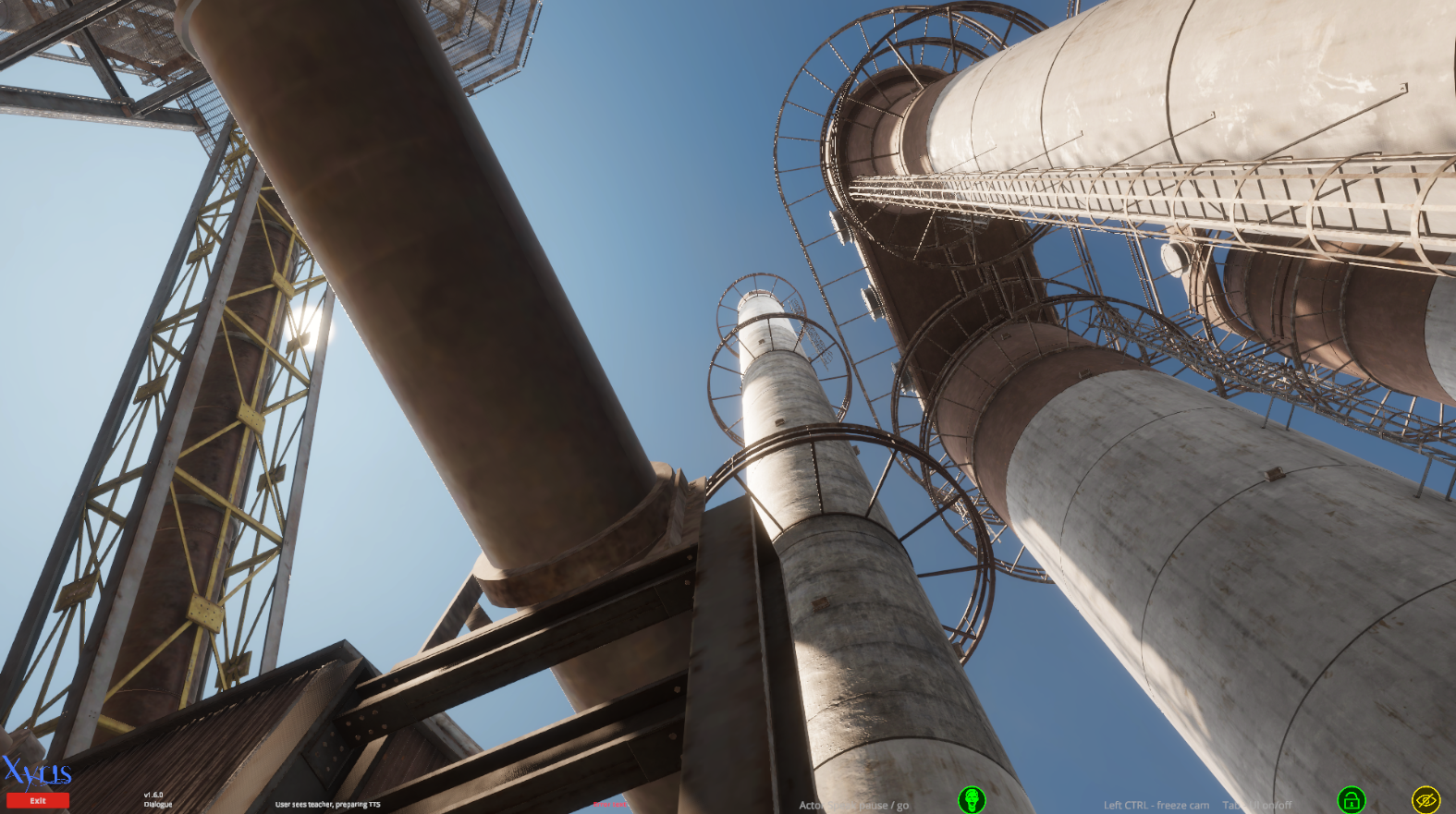 A view looking up of large industrial pipes and structures against a blue sky.